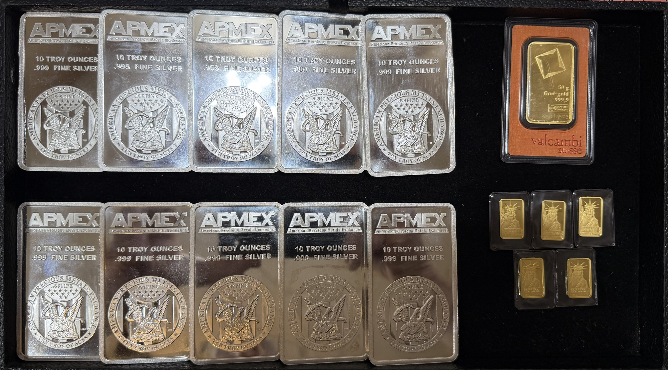 Ten 10 oz APMEX .999 Fine Silver Bars, a Valcambi Suisse 50g gold bar, and several 1g gold bars purchased by Clemson Coins in June 2026